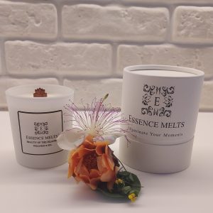 White glass candle labeled Beauty of the Islands- candle on a white surface with soft tropical lighting. Spa candles