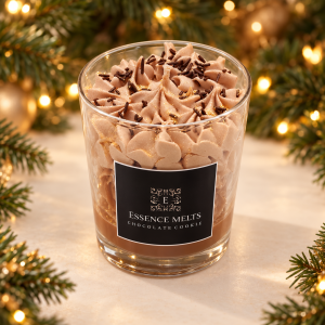 Chocolate Cookie candle with cocoa-coloured whipped wax and dark sprinkles in a clear glass, framed by Christmas greenery and golden lights.