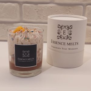 ourmet Pastry - candle by Essence Melts, featuring a glass jar candle with whipped wax, colorful sprinkles, and pastry-shaped accents, displayed with branded packaging. Dessert candles