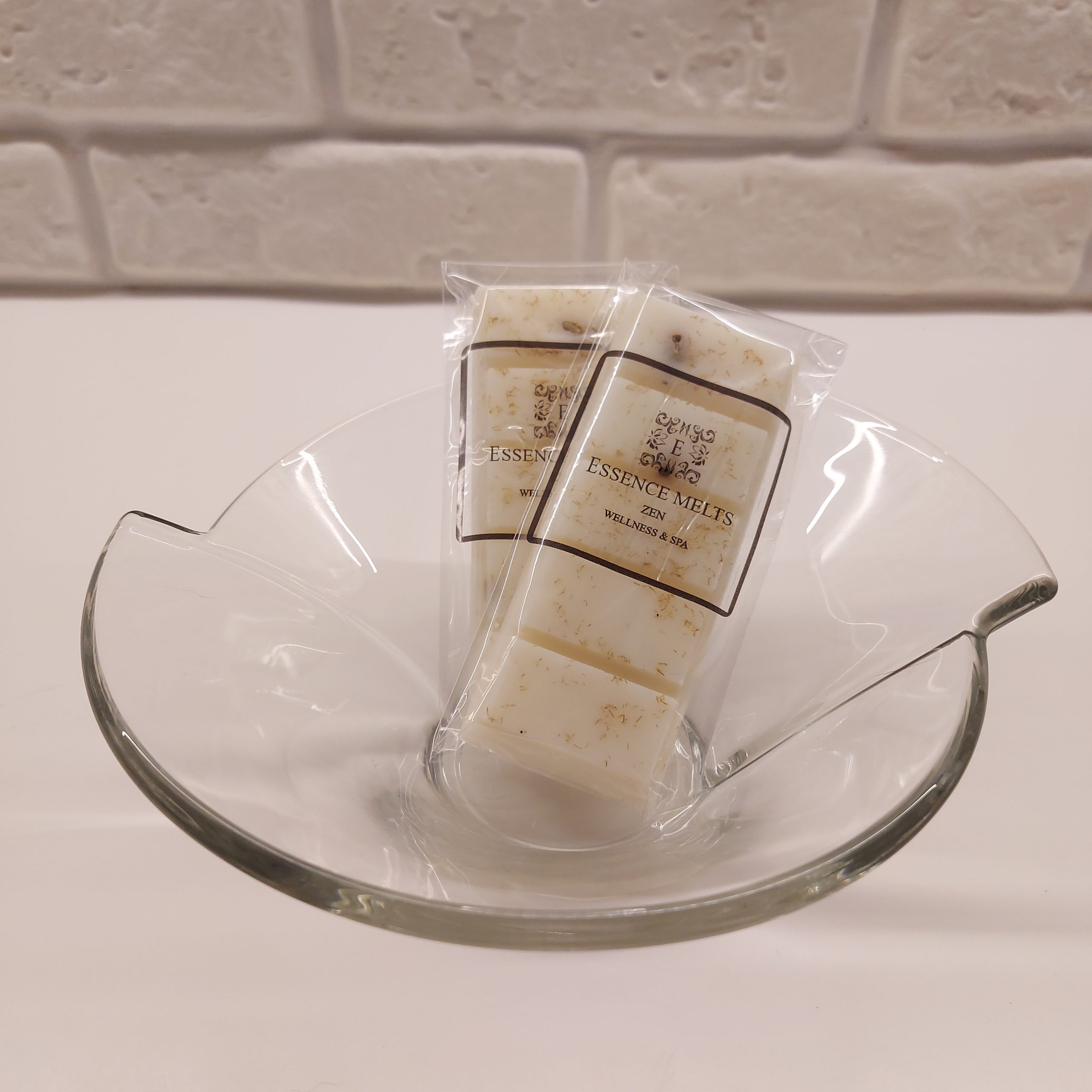 ZEN wax melt snap bar in clear cellophane packaging with Essence Melts logo, placed on a neutral-toned surface.