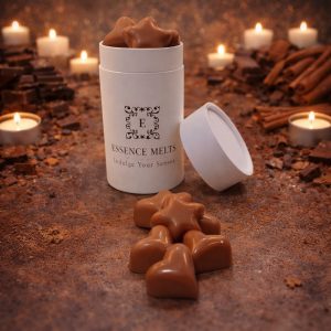 Chocolate Cinnamon scented wax melts in Essence Melts container styled with cocoa powder, chocolate pieces, cinnamon sticks and warm candlelight background.