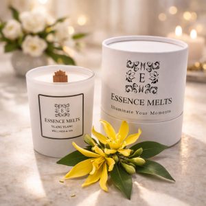 Ylang Ylang Spa Candle burning in a white glass container with a soft glowing flame. a exotic, floral scent. Spa Candles