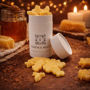 Honeycomb scented wax melts in Essence Melts white container styled with golden honey jar, honey dipper, beeswax comb and warm candlelight background.
