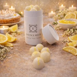 Lemon Meringue scented wax melts in Essence Melts container styled with fresh lemon slices, meringue tart and warm candlelight background.