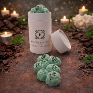 Mint Chocolate scented wax melts in Essence Melts container styled with dark chocolate pieces, fresh mint leaves and warm candlelight background.