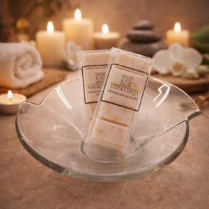 Orange Sandalwood wax melts by Essence Melts styled in a luxury spa setting with candles, orchid flowers and smooth stones.