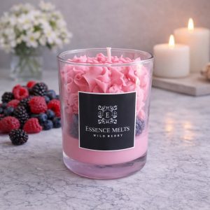 Wild Berry Candle in a clear glass jar with creamy berry-toned wax, topped with realistic wax fruit decorations and styled on a white background.