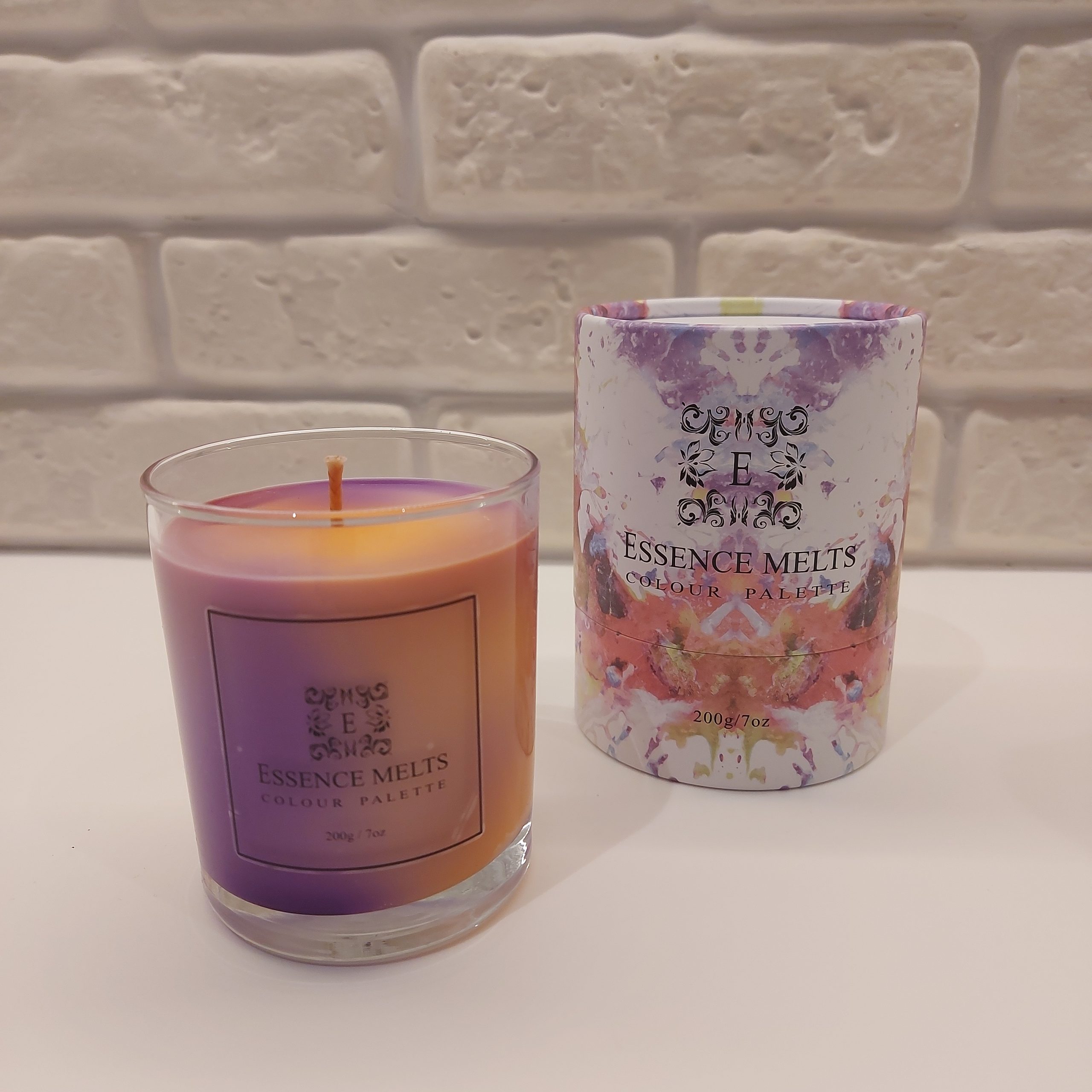 Essence Melts marbled soy wax candle in a clear glass container, featuring vibrant purple and orange swirls Color Palette N1