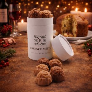 Panettone scented wax melts in white Essence Melts container with cozy Christmas background, candles and festive decor.