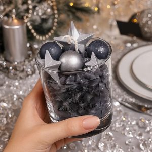 a glass of 200ml piped black wax topped with shining Silver Stars and round silver spheres. new years eve candle
