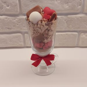 Chocolate Love candle in a glass cup, topped with whipped wax, heart-shaped red wax pieces, and wax chocolate bars.