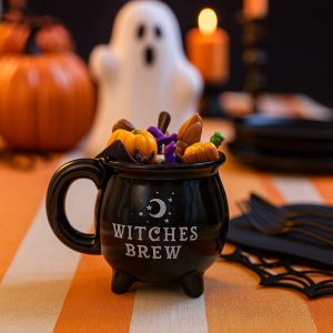 Unpacked Witches Brew Candle in a black ceramic cauldron with a purple witch, broom, pumpkins, skull, and Halloween details.