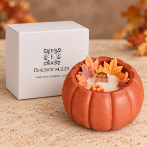Pumpkin spice candle in a terracotta pumpkin-shaped vessel with wax leaves, beside a white Essence Melts gift box.